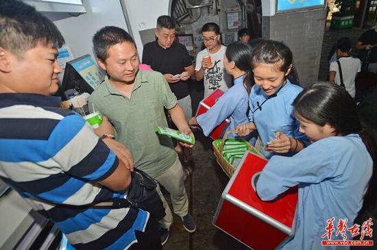 又一位帅哥被“民国女神”们包围，随后慷慨解囊。 记者 李健 摄