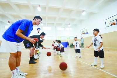 秦淮区鑫园小学的孩子们在篮球俱乐部球员的带领下快乐学球。段仁虎 摄