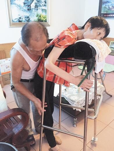 叶荣堂搀扶妻子进行腿部力量训练。